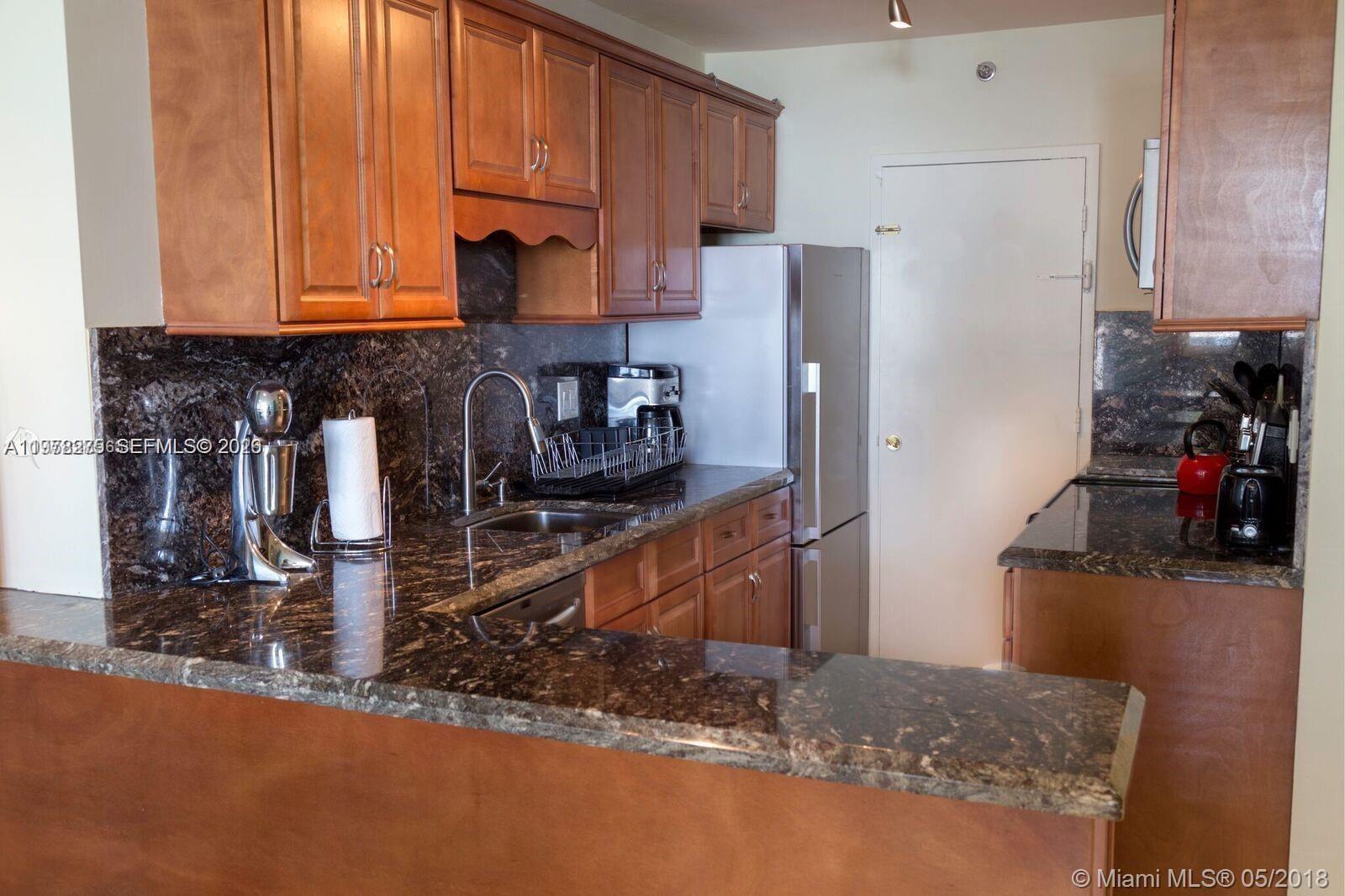 100 Lincoln Road, Unit 521 Miami Beach, FL 33139 - Photo 4 of 9 a kitchen with refrigerator and a stove