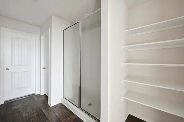 a view of walk in closet with empty racks