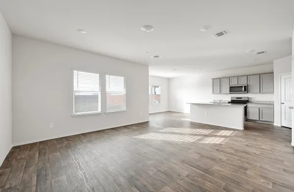 a view of kitchen with granite countertop stainless steel appliances refrigerator sink and cabinets