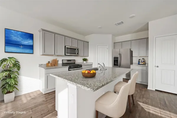 a kitchen with stainless steel appliances granite countertop a refrigerator a stove a sink a dining table and chairs