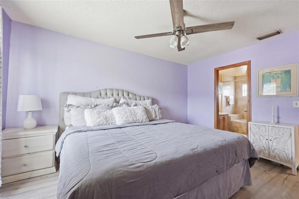 3027 Queens Gate Road Orlando, FL 32818 - Photo 28 of 34 a bedroom with a bed and a chandelier
