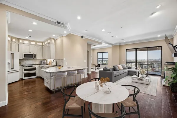 a large kitchen with kitchen island a large counter top space a sink stainless steel appliances and cabinets