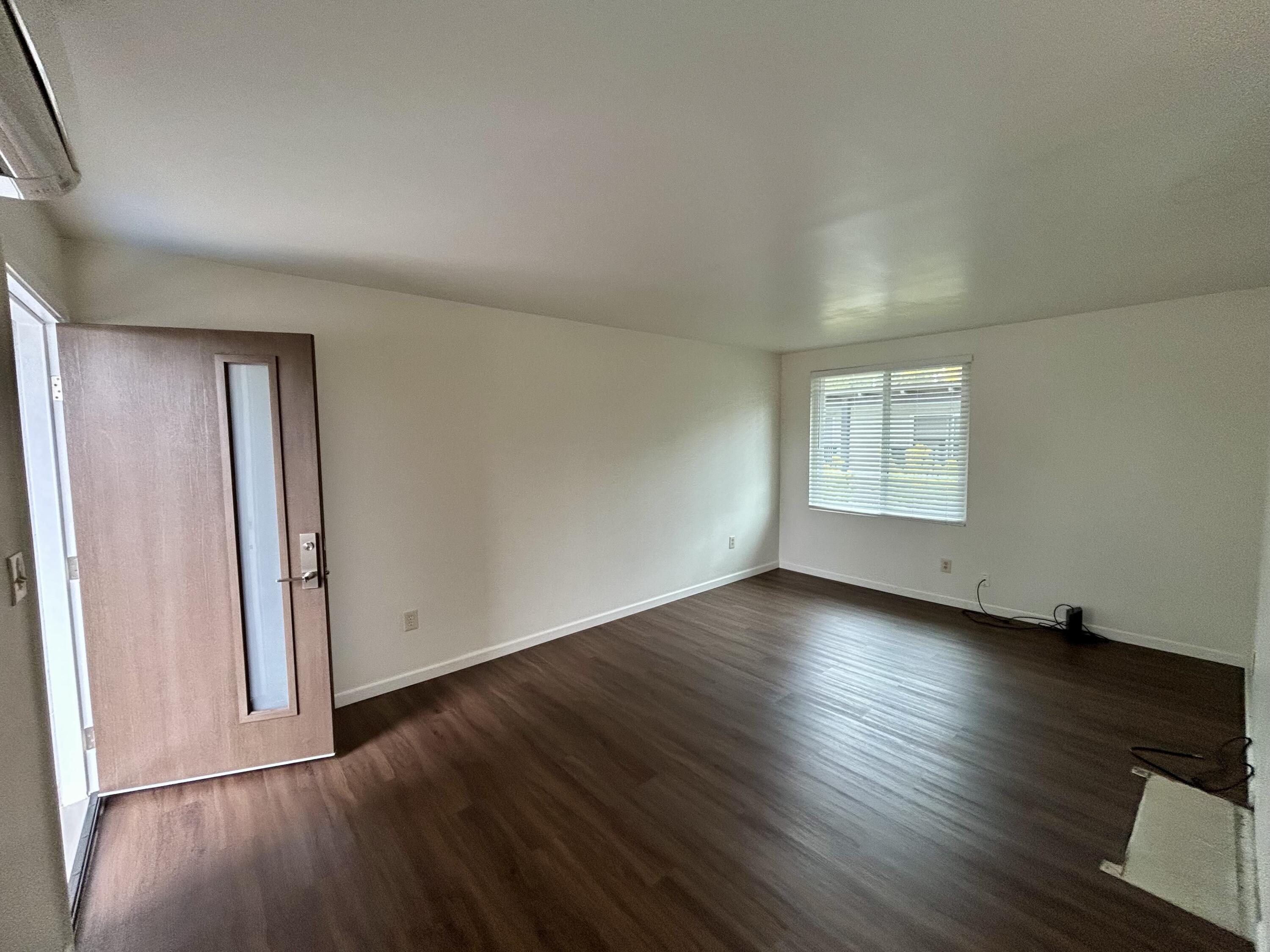 47 Ocean View Avenue, Unit 14 Santa Barbara, CA 93103 - Photo 3 of 9 an empty room with wooden floor and windows