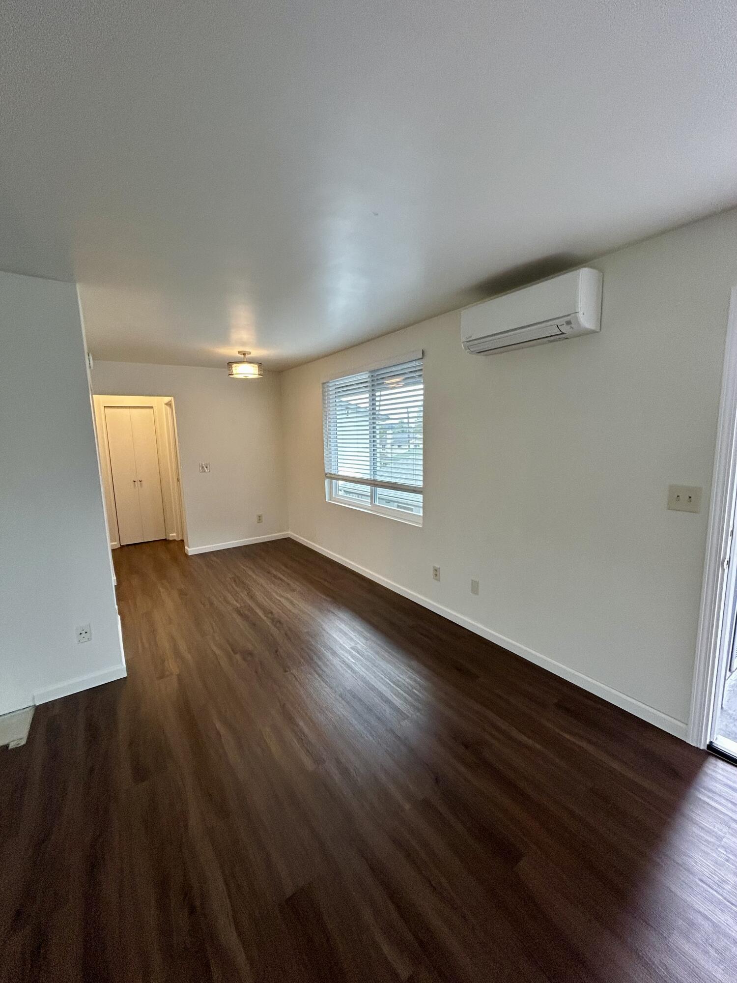 47 Ocean View Avenue, Unit 14 Santa Barbara, CA 93103 - Photo 4 of 9 an empty room with wooden floor and windows