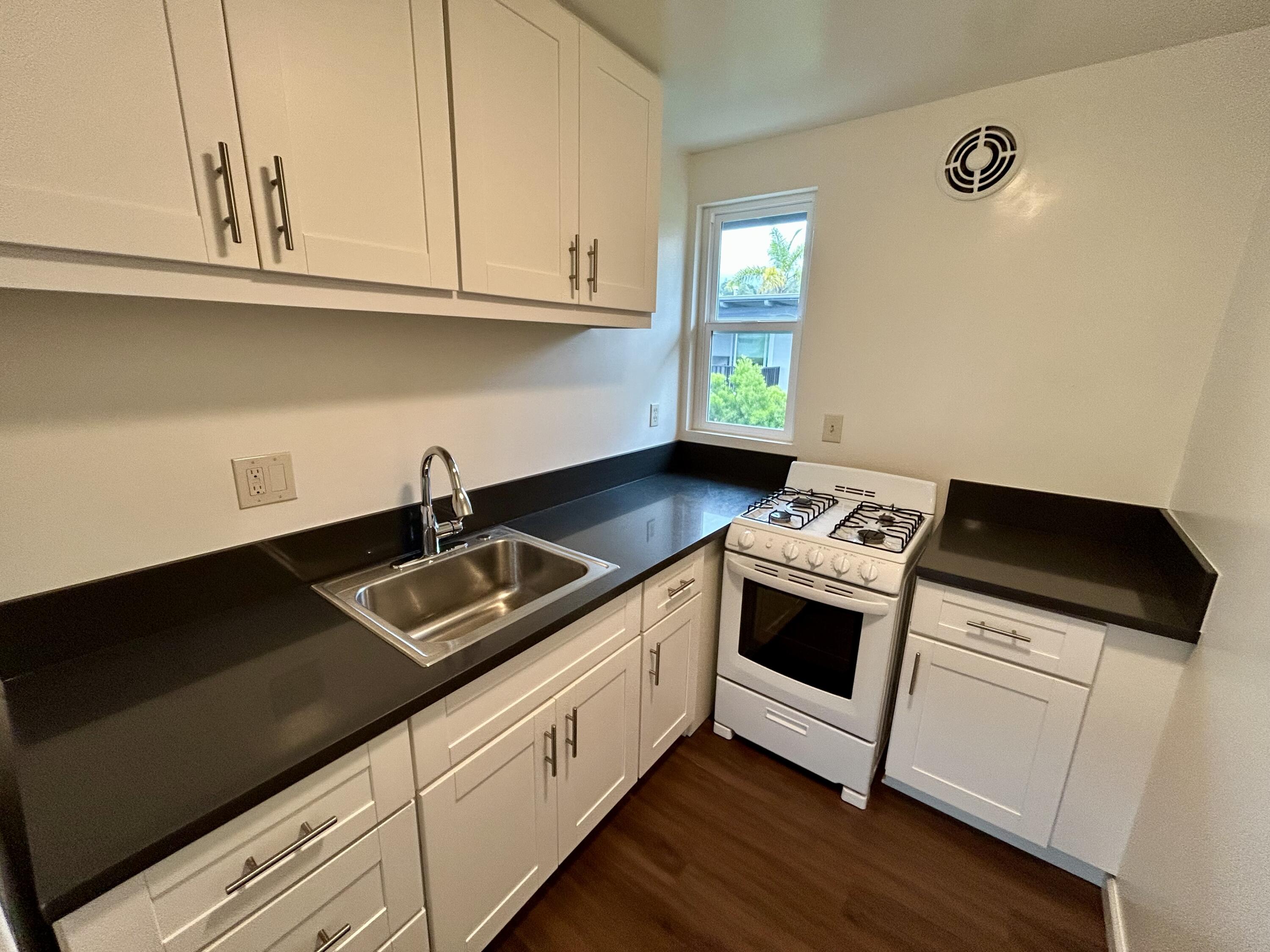 47 Ocean View Avenue, Unit 14 Santa Barbara, CA 93103 - Photo 7 of 9 a kitchen with granite countertop a sink and a stove