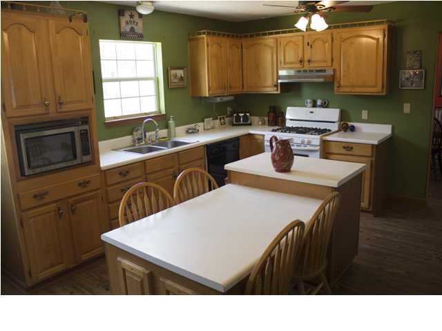 1490 Richardson Road DeFuniak Springs, FL 32433 - Photo 3 of 29 a kitchen with stainless steel appliances a sink a stove a refrigerator a dining table and chairs