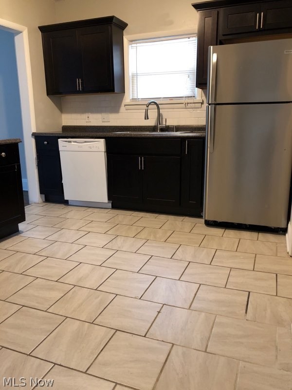 1752 South Taylor Road Cleveland, OH 44118 - Photo 5 of 14 Kitchen featuring dishwasher, tasteful backsplash, stainless steel refrigerator, and light tile floors