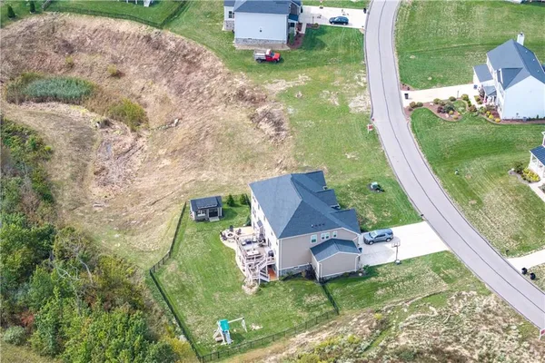 an aerial view of a residential houses with yard