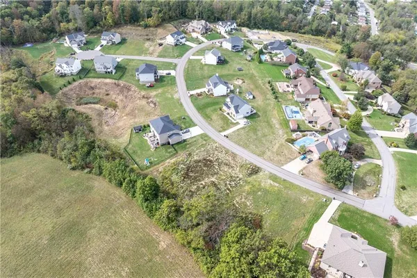 an aerial view of a residential houses with yard