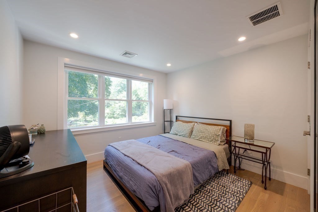 29 Water Street Natick, MA 01760 - Photo 23 of 42 a bedroom with a bed a table and a window