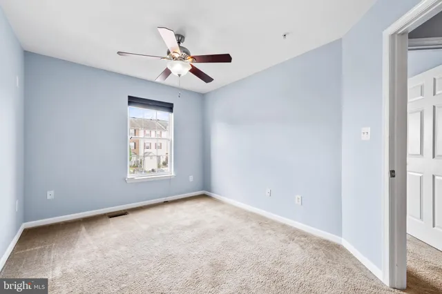 a view of an empty room and a ceiling fan