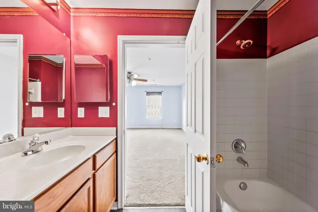 a bathroom with a sink vanity mirror and a bathtub