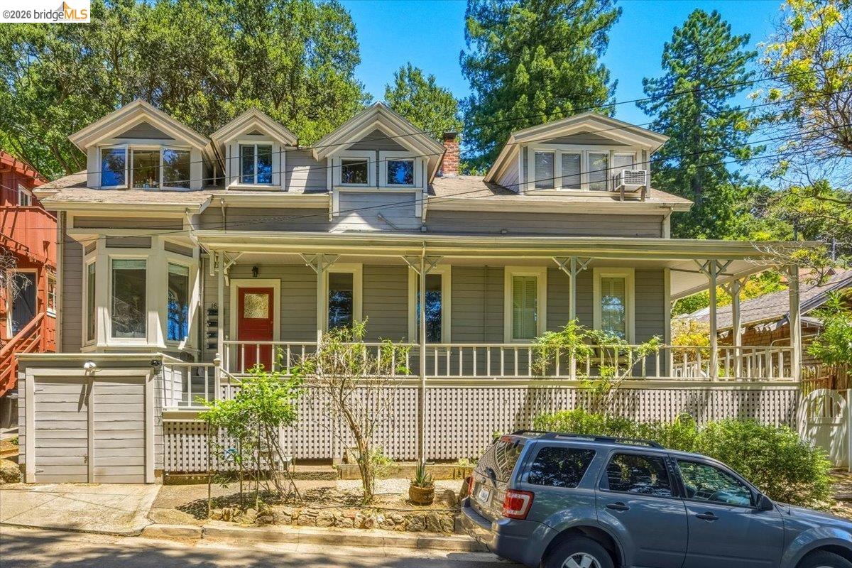 1631 La Vereda Road Berkeley, CA 94709 - Photo 1 of 42 Multi-story residence featuring a covered front porch with decorative trim, bay window, red entry door, and dormer windows