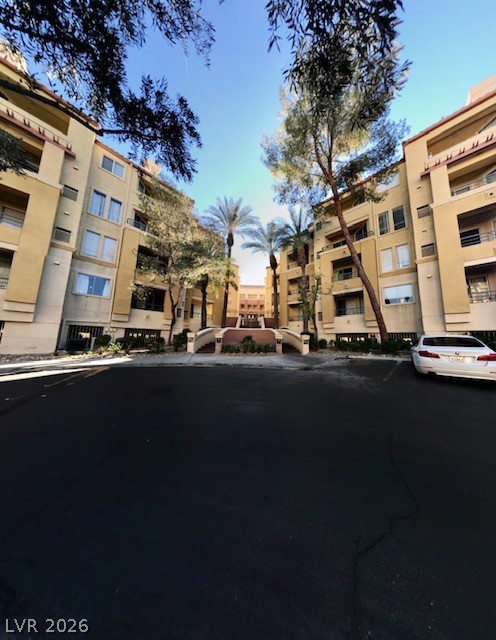 270 East Flamingo Road, Unit 336 Las Vegas, NV 89169 - Photo 1 of 11 This residential complex presents a harmonious blend of architecture and natural landscaping under a clear sky.