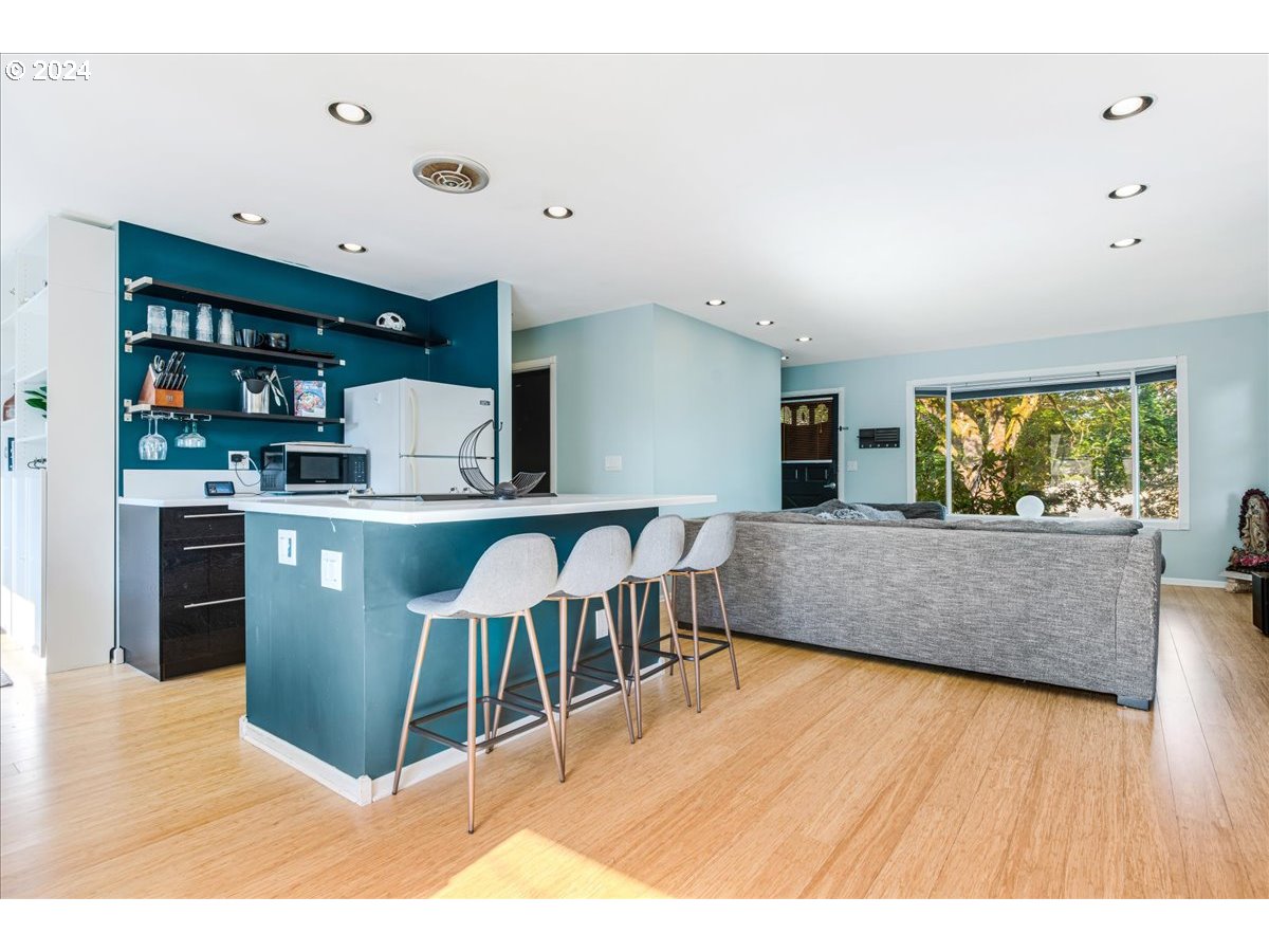 2675 Southwest Spring Garden Street Portland, OR 97219 - Photo 14 of 31 a living room with stainless steel appliances kitchen island granite countertop a table chairs and a wooden floor