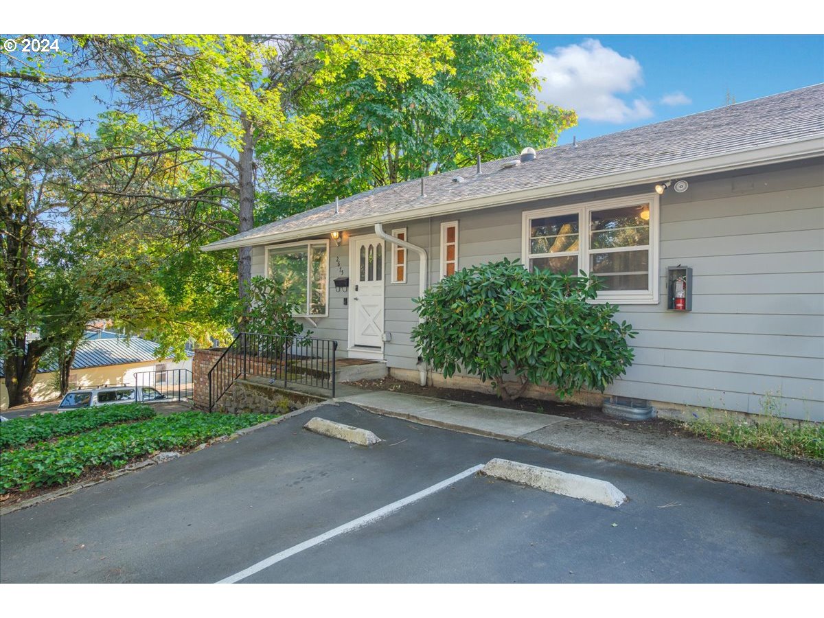 2675 Southwest Spring Garden Street Portland, OR 97219 - Photo 3 of 31 a backyard of a house with potted plants and large tree
