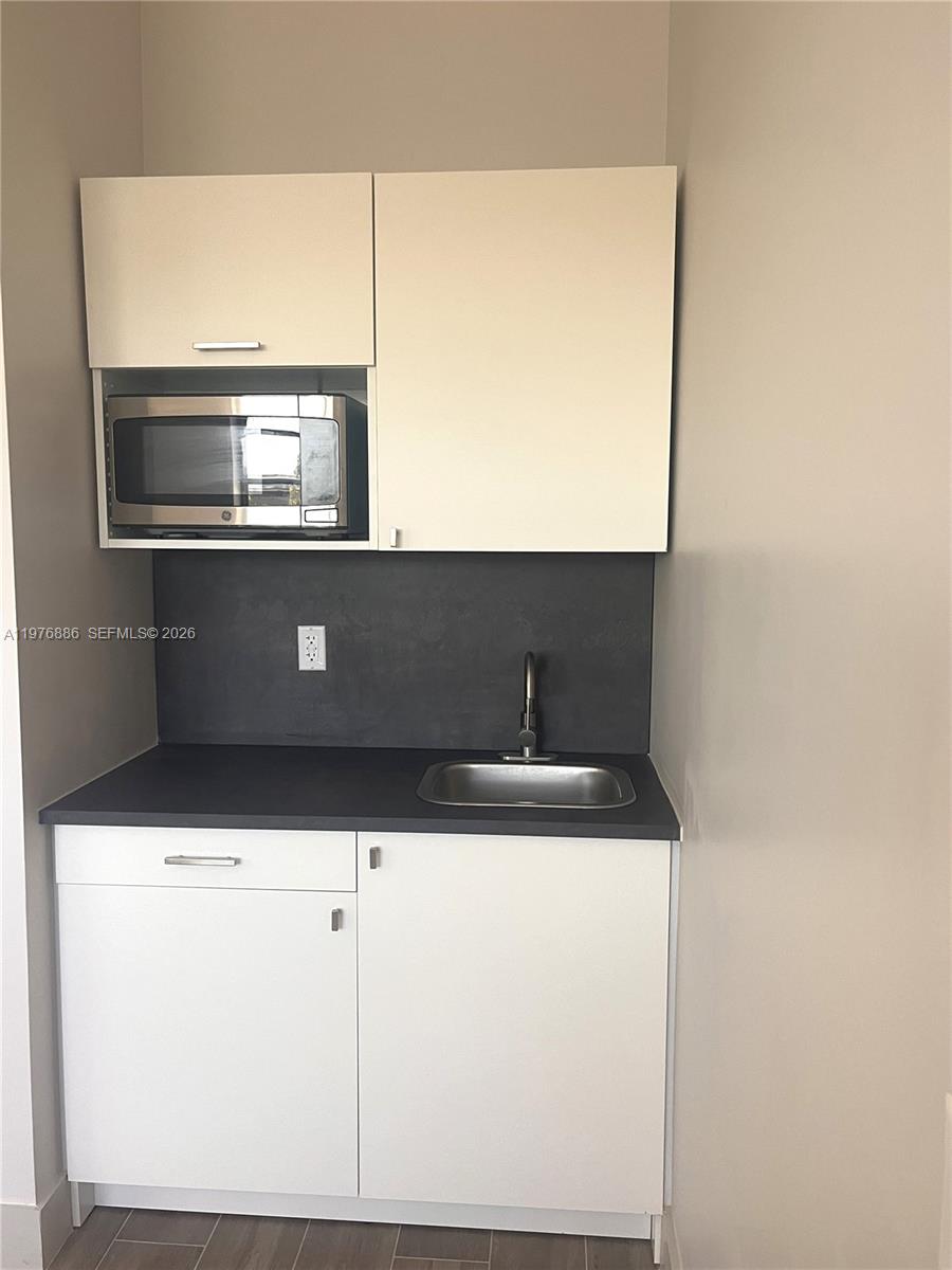 7760 Southwest 20th Street, Unit 1 Miami, FL 33155 - Photo 5 of 7 a kitchen with a sink and a microwave