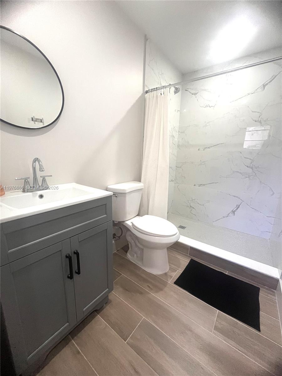 7760 Southwest 20th Street, Unit 1 Miami, FL 33155 - Photo 6 of 7 a bathroom with a sink a toilet and a mirror