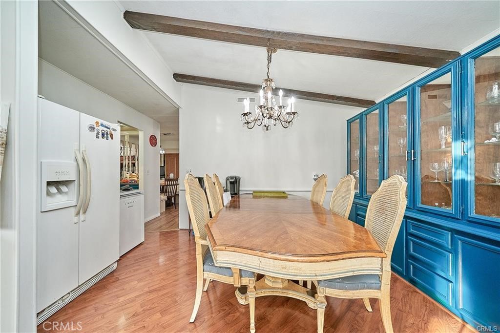 2601 East Victoria Street, Unit 394 Compton, CA 90220 - Photo 9 of 25 a dining room with furniture a chandelier and wooden floor