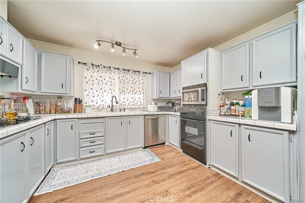 2601 East Victoria Street, Unit 394 Rancho Dominguez, CA 90220 - Photo 10 of 19 a kitchen with granite countertop white cabinets and white appliances