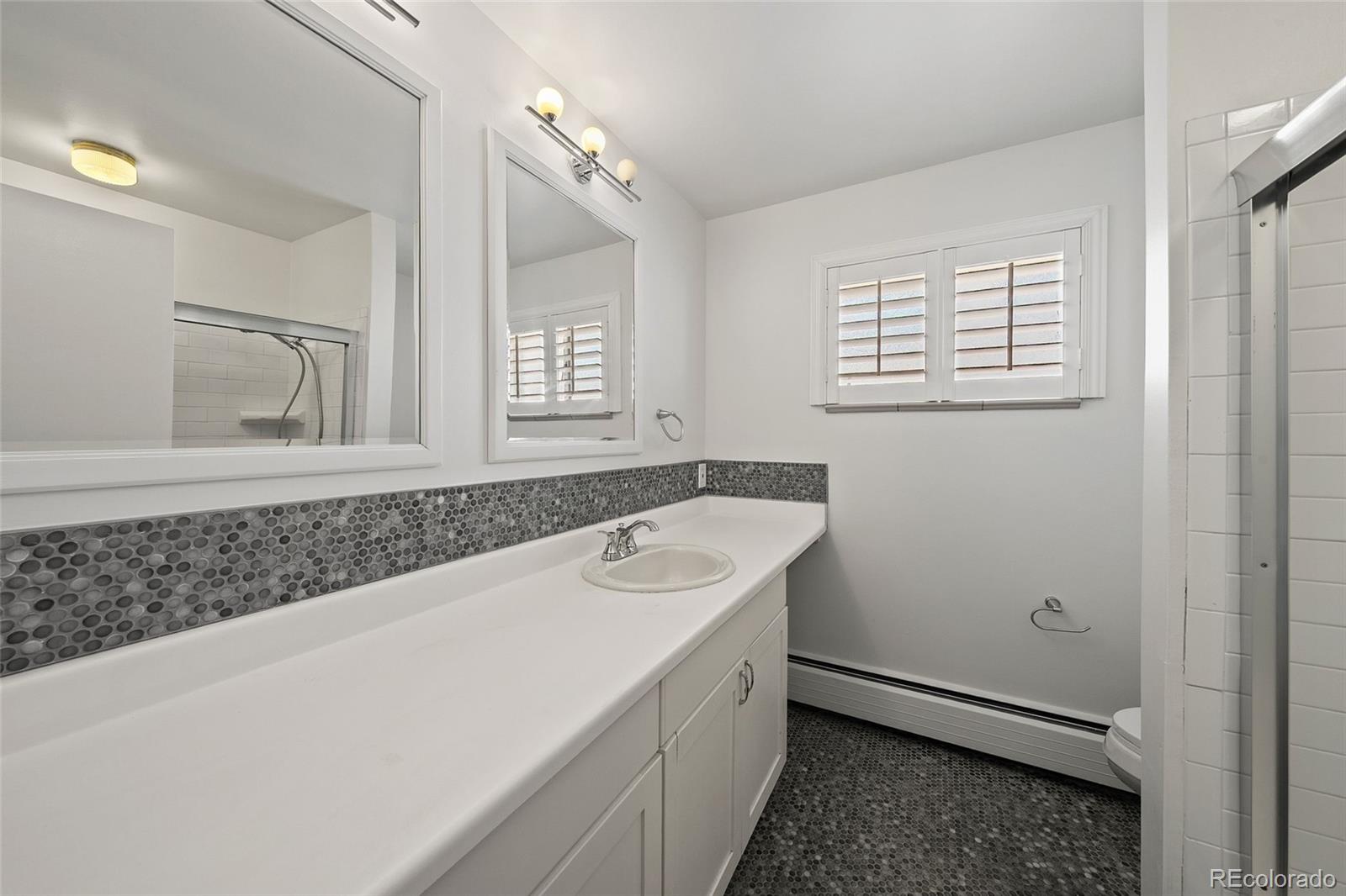 3045 Stuart Street Denver, CO 80212 - Photo 12 of 41 a bathroom with a sink a vanity and a mirror