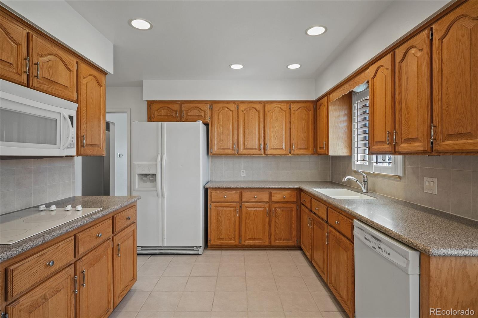 3045 Stuart Street Denver, CO 80212 - Photo 17 of 41 a kitchen with stainless steel appliances granite countertop a refrigerator a sink dishwasher and wooden cabinets
