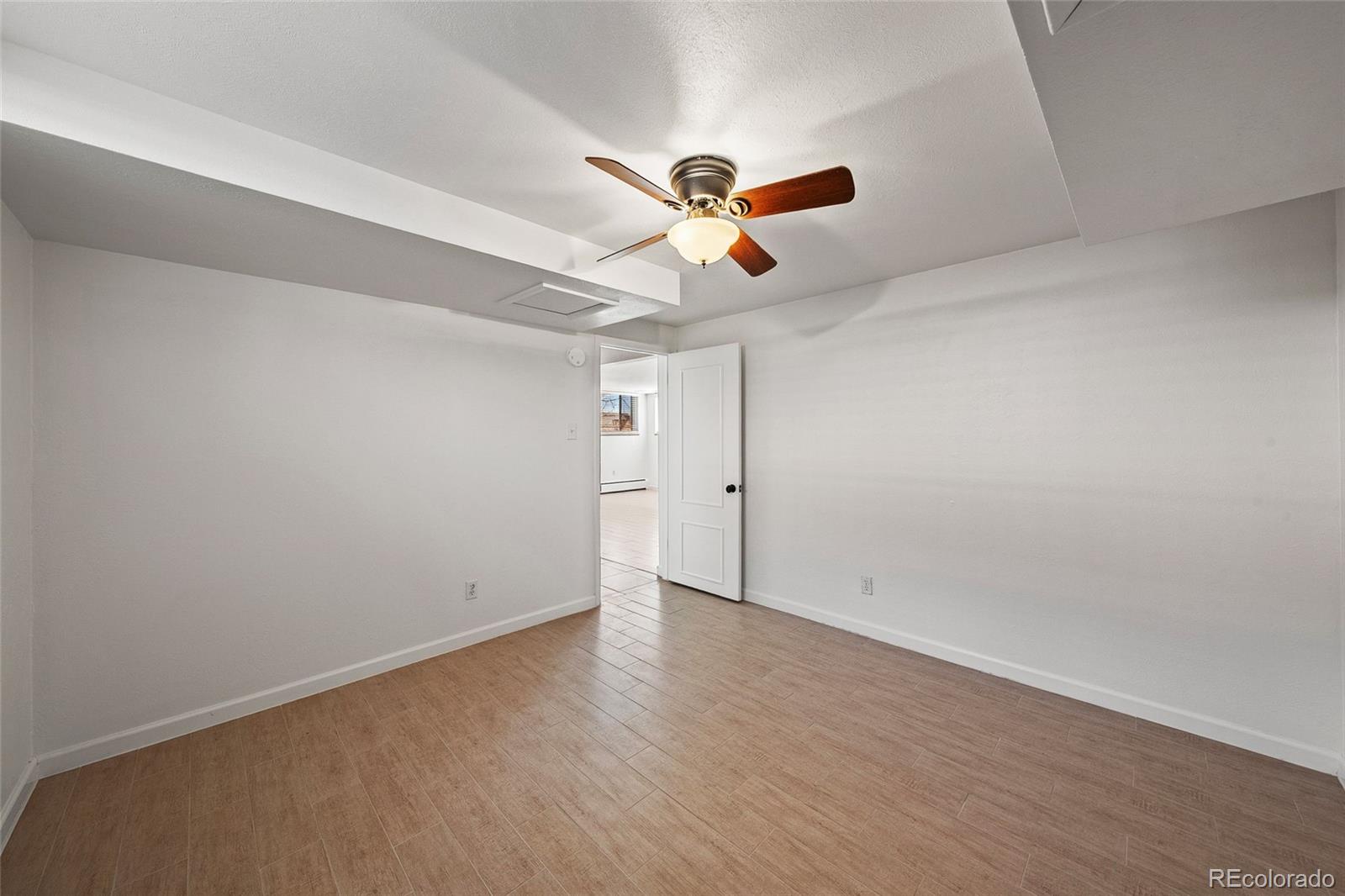 3045 Stuart Street Denver, CO 80212 - Photo 26 of 41 an empty room with a ceiling fan and wooden floor
