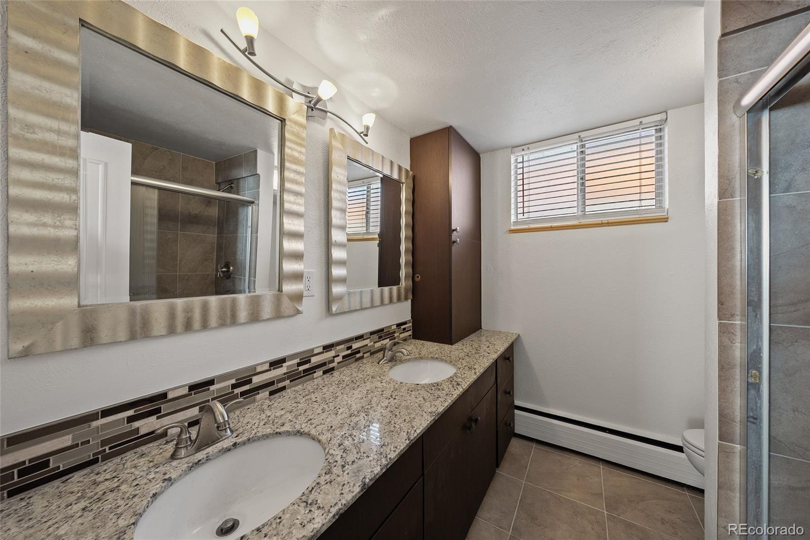 3045 Stuart Street Denver, CO 80212 - Photo 27 of 41 a bathroom with a granite countertop double vanity sink and mirror