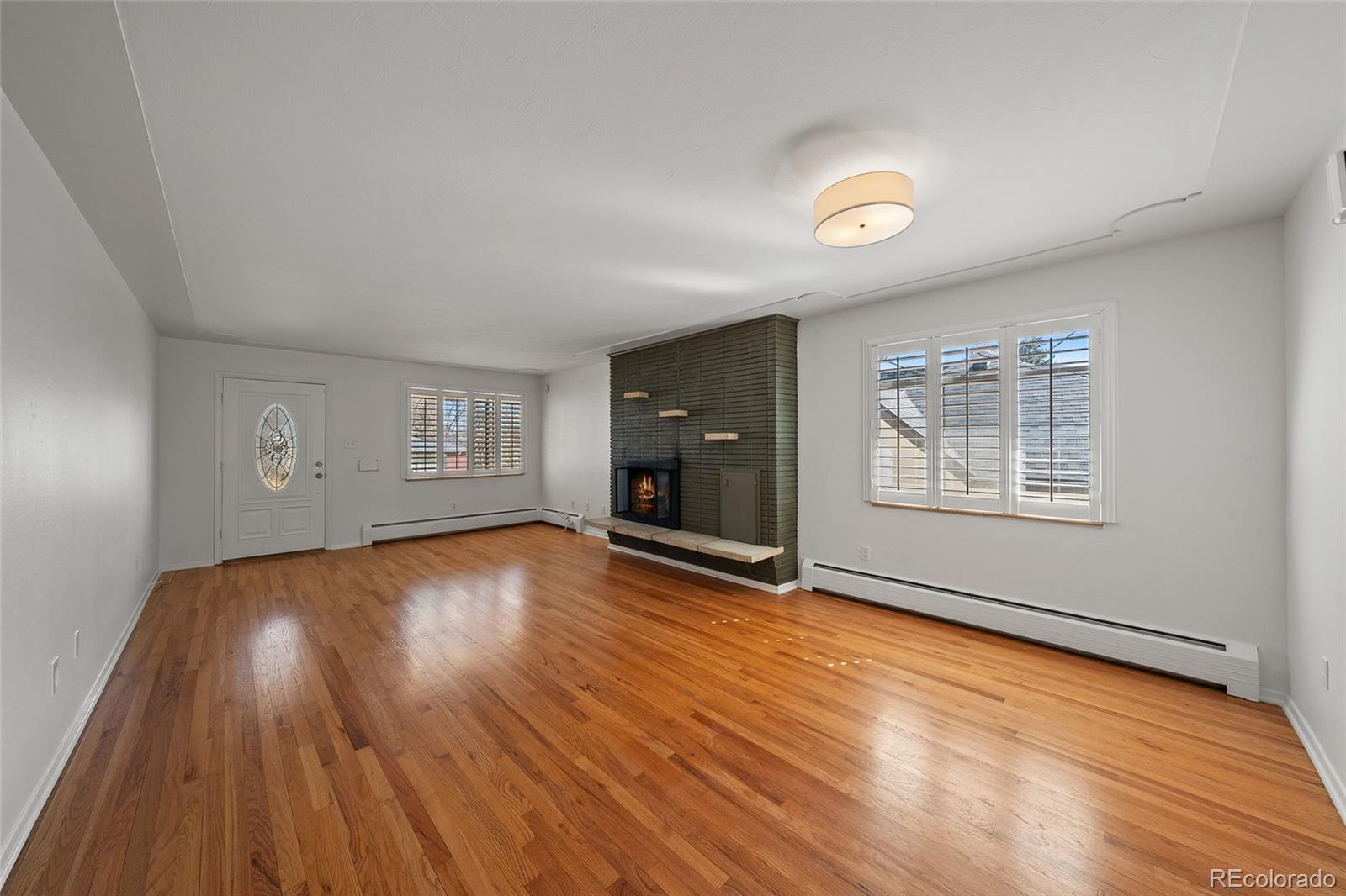 3045 Stuart Street Denver, CO 80212 - Photo 4 of 41 an empty room with wooden floor and windows
