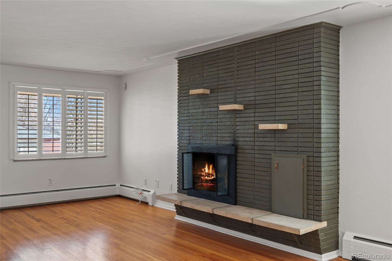 3045 Stuart Street Denver, CO 80212 - Photo 5 of 41 a view of an empty room with wooden floor fireplace and a window