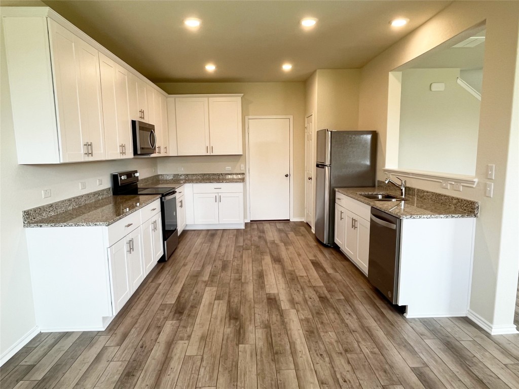 54 Pacific Loon Street Leander, TX 78641 - Photo 5 of 27 a large kitchen with a large counter top a sink stainless steel appliances and cabinets