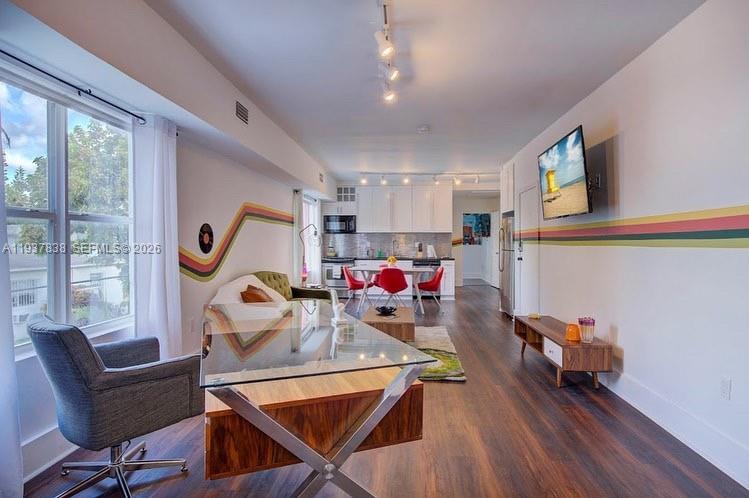a view of a dining room with furniture a chandelier windows and wooden floor