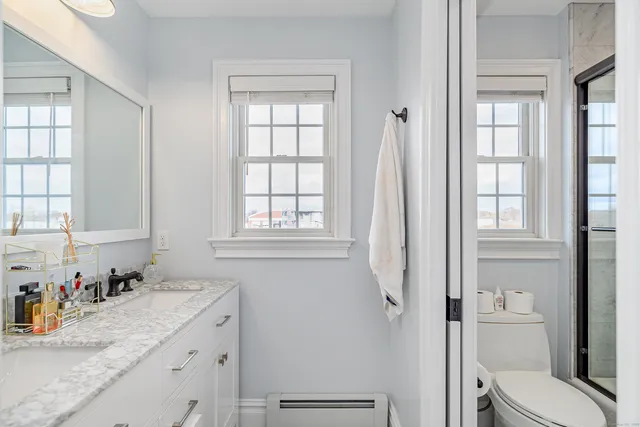 a bathroom with a granite countertop sink toilet and shower