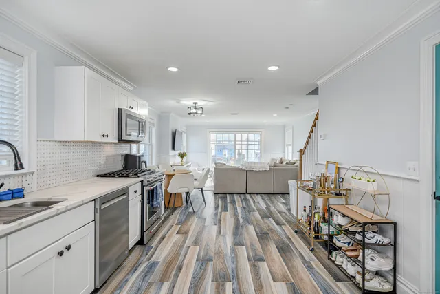 a large kitchen with stainless steel appliances a lot of counter space and a wooden floors