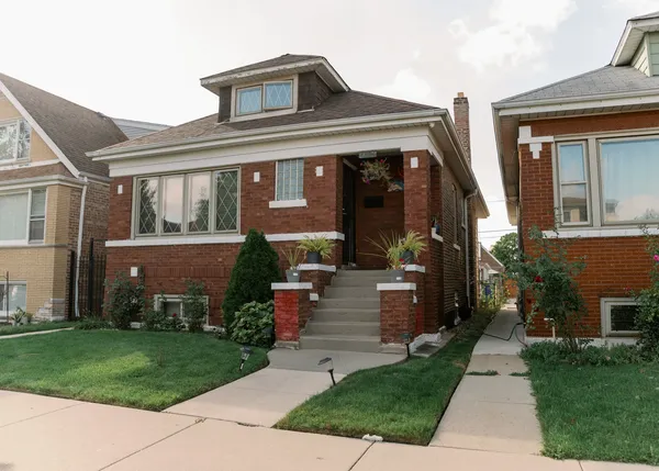 a front view of house with a garden