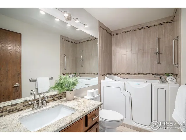 a bathroom with a granite countertop sink mirror vanity and toilet