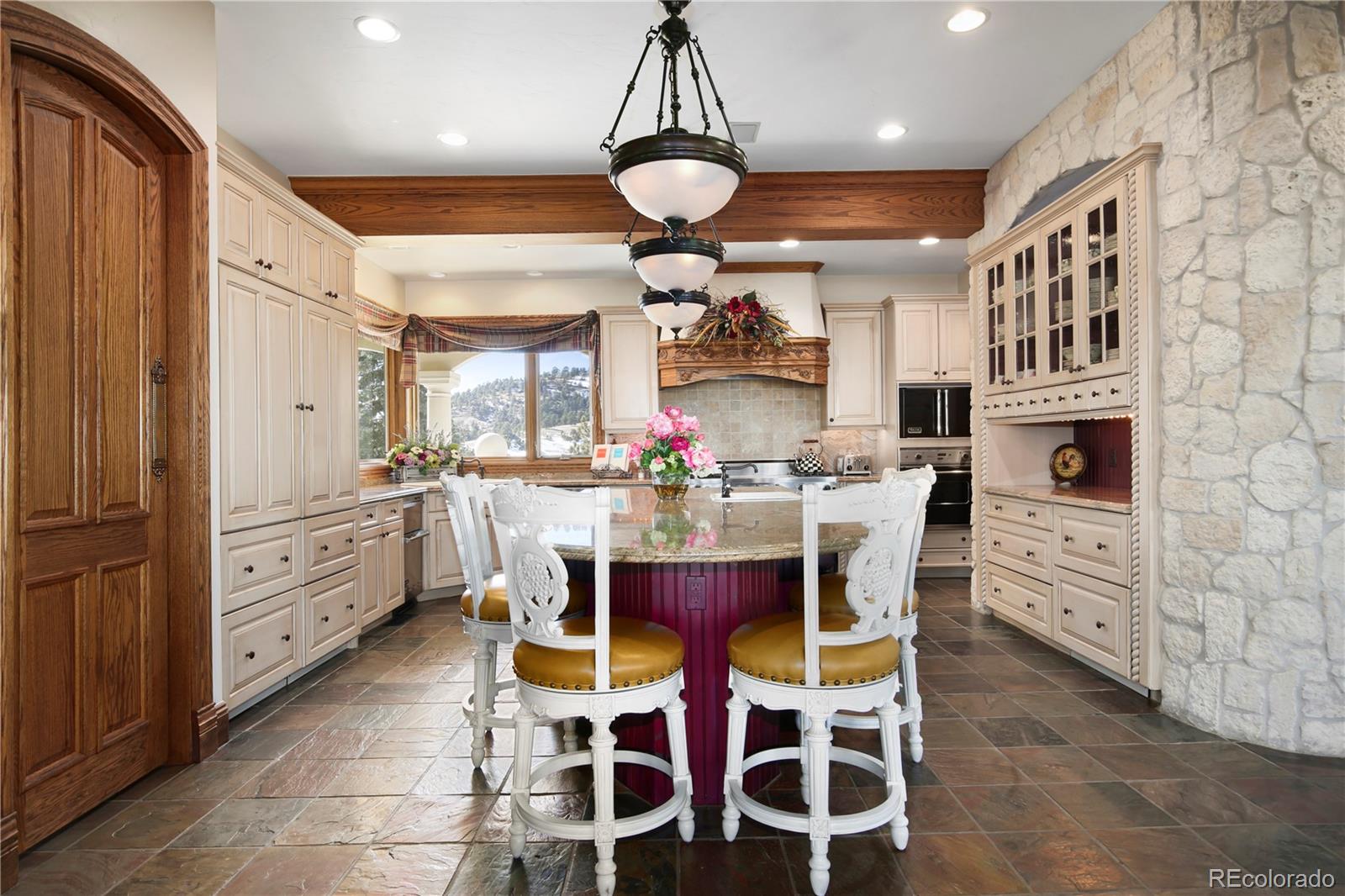 1334 South Grapevine Road Golden, CO 80401 - Photo 13 of 36 a kitchen with stainless steel appliances kitchen island granite countertop a table chairs and a chandelier