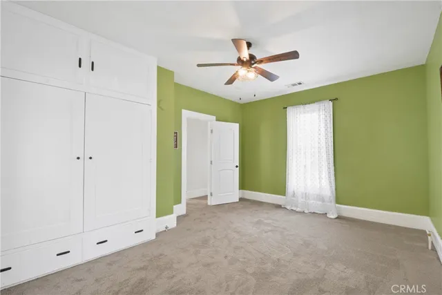 a view of a big room with chandelier fan and windows