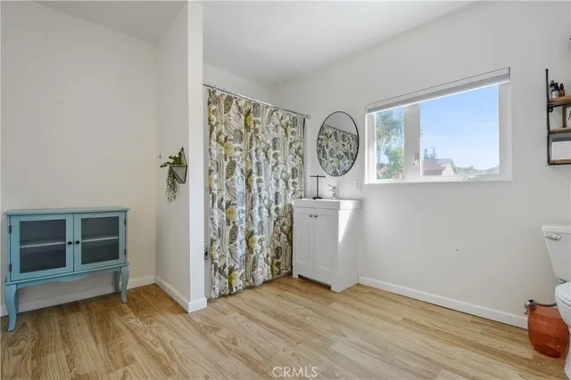 a view of an empty room with window and wooden floor