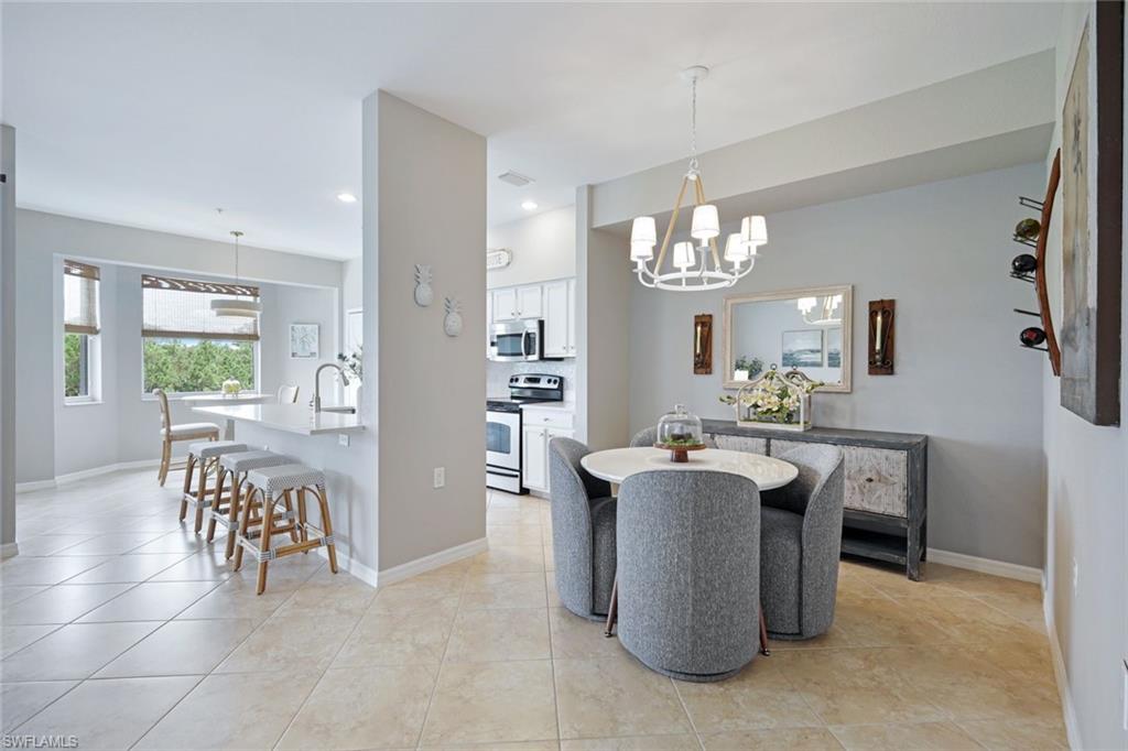 10329 Heritage Bay Boulevard, Unit 1641 Naples, FL 34120 - Photo 13 of 22 Dining space with a chandelier, recessed lighting, baseboards, and light tile patterned flooring