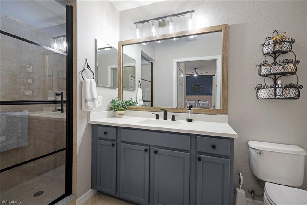 10329 Heritage Bay Boulevard, Unit 1641 Naples, FL 34120 - Photo 17 of 22 Bathroom with toilet, vanity, and a shower stall