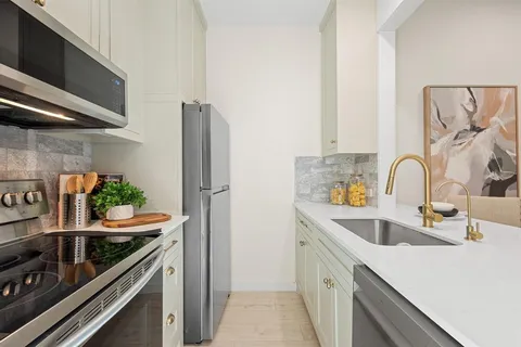 a kitchen with stainless steel appliances a sink stove and refrigerator