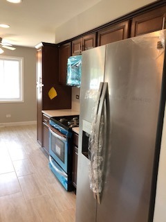 5204 State Road Burbank, IL 60459 - Photo 22 of 30 a kitchen with granite countertop a refrigerator and a stove