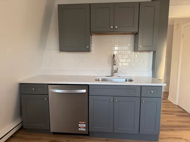 a room with granite countertop cabinets and wooden floor