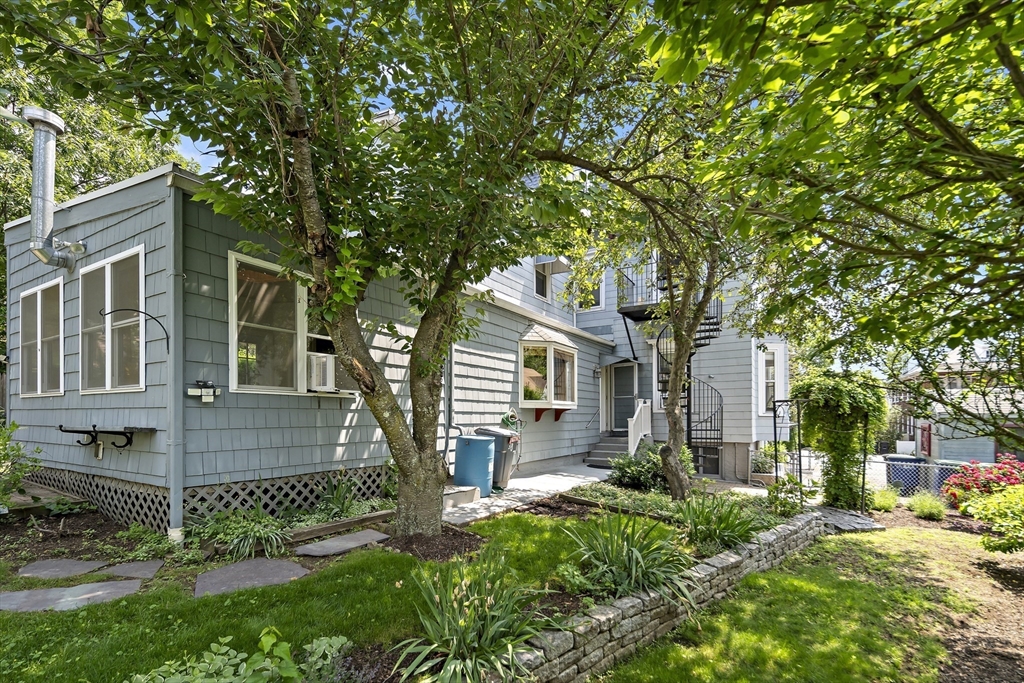 38 Spring Street, Unit 3 Somerville, MA 02143 - Photo 16 of 19 a front view of a house with a garden