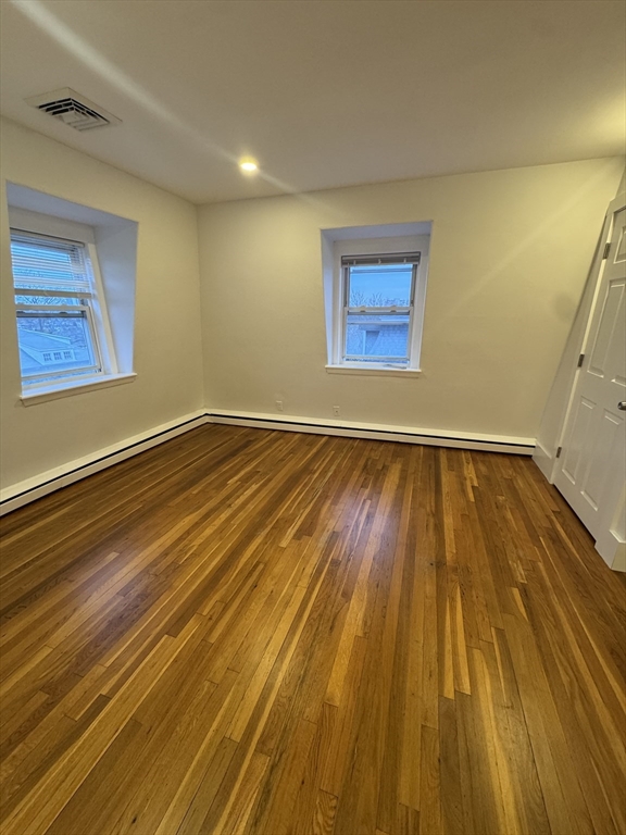 38 Spring Street, Unit 3 Somerville, MA 02143 - Photo 4 of 19 a view of an empty room with wooden floor