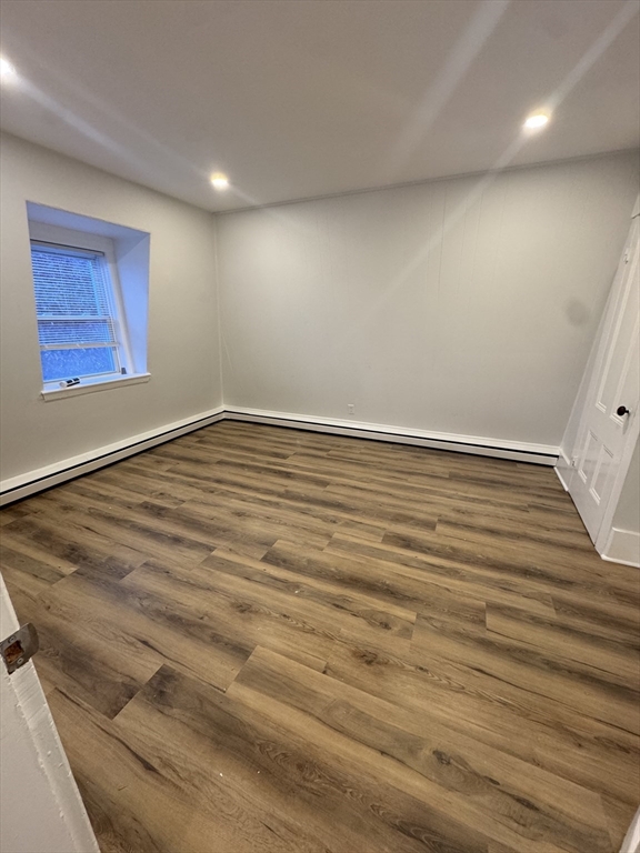 38 Spring Street, Unit 3 Somerville, MA 02143 - Photo 7 of 19 an empty room with wooden floor and windows