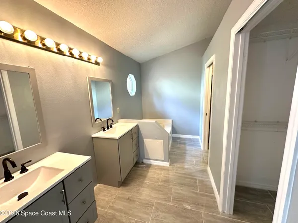 a bathroom with a tub sink and mirror