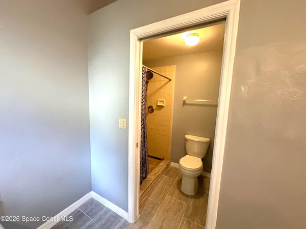 a bathroom with a toilet and a shower