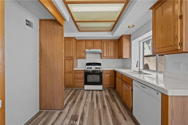 a kitchen with a sink a stove top oven and cabinetry